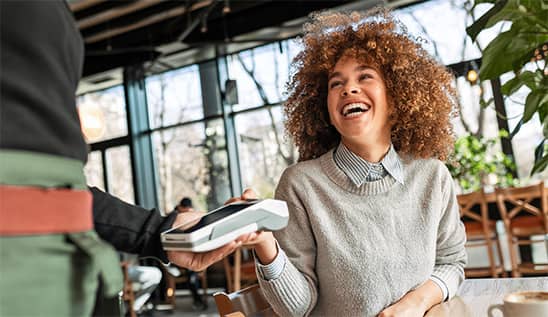 smiling woman holding card machine